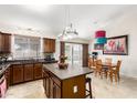 Open kitchen boasts ample cabinet space, center island with seating, and adjacent dining area overlooking the pool at 1207 E Sequoia Dr, Phoenix, AZ 85024