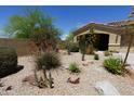 View of the front of the house with desert landscaping including rocks, arid plants, and a low wall at 18436 W Shasta St, Goodyear, AZ 85338