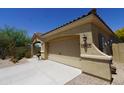 Two car garage featuring carriage doors, stucco facade, and address numbers on the side at 18436 W Shasta St, Goodyear, AZ 85338