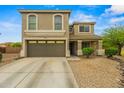 This two-story home features desert landscaping, a two-car garage, and a charming front porch at 21033 N Alexis Ave, Maricopa, AZ 85138