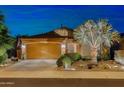 Charming single-story home with a well-manicured front yard and a two-car garage at twilight at 4200 E Narrowleaf Dr, Gilbert, AZ 85298