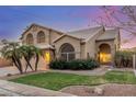 Inviting home featuring desert landscaping, a lush green lawn and blooming red rose bushes at 2022 N 124Th Dr, Avondale, AZ 85392