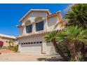 Attractive two-story home with a three-car garage and desert landscaping with palms at 21483 N 65Th Ave, Glendale, AZ 85308