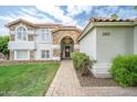 Inviting front entrance with a brick walkway leading to an arched doorway and meticulously manicured landscaping at 2431 E Laurel St, Mesa, AZ 85213