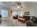 Spacious living room with wood-look flooring, ceiling fan, and comfortable leather furniture at 329 S Marin Dr, Gilbert, AZ 85296