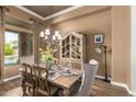 Elegant dining room with chandelier, wood floors, and decorative hutch at 41715 N River Bend Rd, Phoenix, AZ 85086
