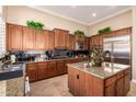 Spacious kitchen featuring granite countertops, stainless steel refrigerator, and wooden cabinets at 41715 N River Bend Rd, Phoenix, AZ 85086