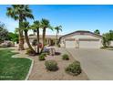 Charming single-story home with lush landscaping, palm trees, and a two-car garage, creating a welcoming curb appeal at 4230 E Fountain St, Mesa, AZ 85205