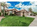 Well-maintained home with lush green lawn, mature trees, and a spacious three-car garage at 4620 E Desert Cactus St, Phoenix, AZ 85032