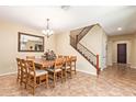 Bright dining room showcasing a large table, chandelier, staircase, and tile floors at 882 E Parkview Dr, Gilbert, AZ 85295