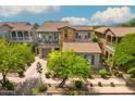 This aerial shot showcases a charming home with a balcony, tile roof, and lush greenery surrounding the property at 9433 E Trailside Vw, Scottsdale, AZ 85255