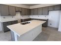Spacious kitchen featuring gray cabinets, an island with a sink, and white subway tile backsplash at 20601 N 226Th Dr, Surprise, AZ 85387