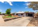 Spacious single-story home with a long driveway, covered carport, and a well-maintained front yard at 2122 W Piccadilly Rd, Phoenix, AZ 85015
