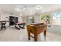 Bright game room with multiple ceiling fans, large windows and a variety of games at 2122 W Piccadilly Rd, Phoenix, AZ 85015