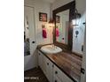 Bathroom features a wooden countertop, framed mirror, and decorative rustic sconces at 2511 N 56Th St, Mesa, AZ 85215
