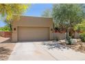 Exterior view showcasing the spacious three-car garage, complemented by well-maintained landscaping and a charming entryway at 28045 N 112Th Pl, Scottsdale, AZ 85262