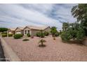 Expansive, well-kept yard with desert landscaping, mature trees, and a view of the single story home at 3022 N 148Th Ave, Goodyear, AZ 85395