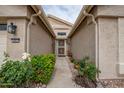 Inviting front entrance featuring a decorative security door, desert landscaping, and a well-lit porch at 3022 N 148Th Ave, Goodyear, AZ 85395