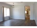 Bright, open-concept living room featuring tile flooring, a neutral color palette, and an arched doorway at 3559 N 143Rd Ave, Goodyear, AZ 85395