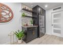 Stylish bar area with dark cabinetry, open shelving, and stainless steel refrigerator at 5995 N 78Th St # 2078, Scottsdale, AZ 85250