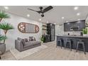 Open-concept living room features a plush gray sofa, unique wall art, and a modern kitchen bar at 5995 N 78Th St # 2078, Scottsdale, AZ 85250