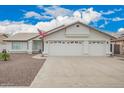 Charming single-story home showcasing a three-car garage and manicured desert landscaping at 8516 W Saint John Rd, Peoria, AZ 85382
