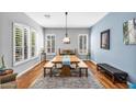 Bright dining room with large windows, hardwood floors, and contemporary lighting at 8703 E Nora St, Mesa, AZ 85207