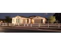 Inviting single-story home with a tidy front yard and white picket fence on a neatly paved street at dusk at 9924 E Strobe Ave, Mesa, AZ 85212
