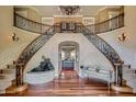 Elegant foyer with dual staircase, ornate iron railings, and chandelier at 12240 S Honah Lee Ct, Phoenix, AZ 85044