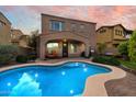 Private backyard featuring a sparkling pool, covered patio with seating, and well-maintained landscaping at 13648 W Jesse Red Dr, Peoria, AZ 85383