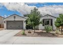 Charming single-story home featuring a two-car garage and desert landscaping at 21840 N 260Th Ln, Buckeye, AZ 85396