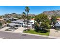 Aerial view of modern house with a 3 car garage, a mountain backdrop and manicured lawn at 2308 E State Ave, Phoenix, AZ 85020