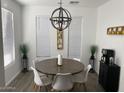 Bright dining room with stylish chandelier, wood-look floors, and large windows at 6557 S Classic Way, Gilbert, AZ 85298