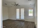 Bright living room with wood-look floors, ceiling fan, and access to the backyard through french doors at 6557 S Classic Way, Gilbert, AZ 85298