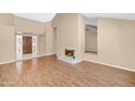 Spacious living room with wood-look flooring, fireplace, and a front door with decorative glass at 8666 E Cheryl Dr, Scottsdale, AZ 85258