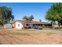 Single-story home with a large lot, driveway, and mature trees at 11422 W Hidalgo Ave, Tolleson, AZ 85353