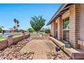 A quaint patio area in the front yard, featuring brick pavers, stone accents, and lush greenery at 1210 W Stottler Dr, Chandler, AZ 85224