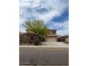 Charming two-story home with a three-car garage and desert landscaping with a tree-lined street at 12518 W Milton Dr, Peoria, AZ 85383