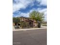 Charming two-story home with a three-car garage, desert landscaping and a tree-lined street at 12518 W Milton Dr, Peoria, AZ 85383