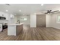 Open living area with view into kitchen, wood floors, decorative wood panel and ceiling fan at 1313 N 71St St, Scottsdale, AZ 85257