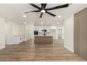 Spacious living room with wood floors, ceiling fan, and updated kitchen in the background at 1313 N 71St St, Scottsdale, AZ 85257