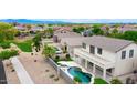 Backyard oasis featuring a sparkling pool, spa, and patio perfect for entertaining or relaxing, with desert landscaping at 14823 W Windsor Ave, Goodyear, AZ 85395