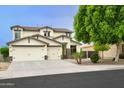 Two-story home featuring a three-car garage, desert landscaping, stone accents and a charming outdoor seating area at 14823 W Windsor Ave, Goodyear, AZ 85395