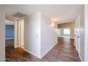 Bright hallway with wood-look flooring, leading to the bedrooms, living room, and kitchen at 17238 N 107Th Ave, Sun City, AZ 85373