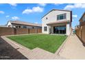 New back yard features a green lawn, a covered patio, and a block wall for a private outdoor area at 20181 W Desert Bloom St, Buckeye, AZ 85326