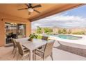 Covered patio with seating area, ceiling fan, and scenic views of the pool and distant mountains at 2930 E Quiet Hollow Ln, Phoenix, AZ 85024
