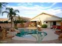 Inviting backyard pool with rock features, lush landscaping, and a covered patio area at 3152 N 83Rd Pl, Scottsdale, AZ 85251