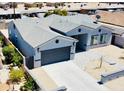 Stunning exterior showcasing the large driveway, landscaped yard, neutral color palette and gray trim of this charming home at 32101 W Palo Verde St, Wittmann, AZ 85361