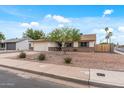 Street view of the house, showing the two-car garage, desert landscaping and proximity to the neighborhood at 3407 E Pueblo Ave, Mesa, AZ 85204