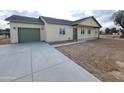 Side view of a stucco home with a green garage door, long driveway and landscaped yard at 350 N Florence St, Florence, AZ 85132